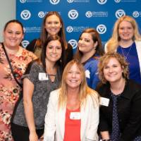 tom and marcia pose for picture with 7 women